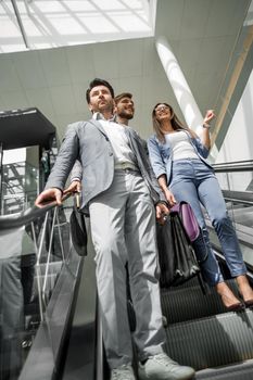 group of business people standing on the steps of the escalator .business concept