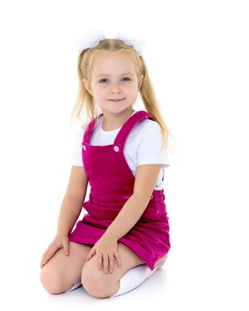 Beautiful little girl kneels in the studio on a white background. The concept of beauty and fashion, children's emotions. Isolated.