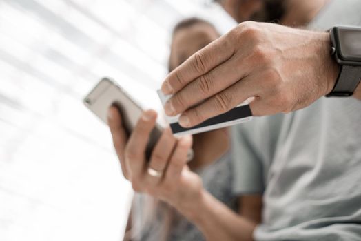 close up.young couple using smartphone to buy.people and technology