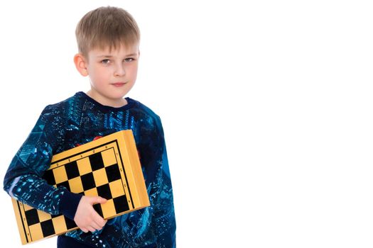 Cute little boy with a chessboard. The concept of children's and developing games in chess, checkers. Isolated on white background.