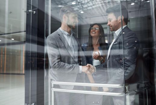 colleagues shaking hands in the Elevator.business concept