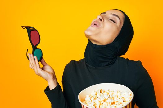 pretty woman in black hijab popcorn 3D glasses cinema ethnicity model. High quality photo
