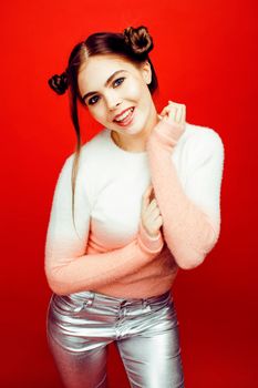 young pretty emitonal posing teenage girl on bright red background, happy smiling lifestyle people concept close up