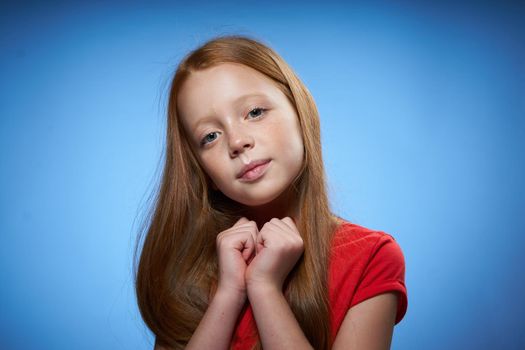 cheerful cute red-haired girl childhood blue background. High quality photo