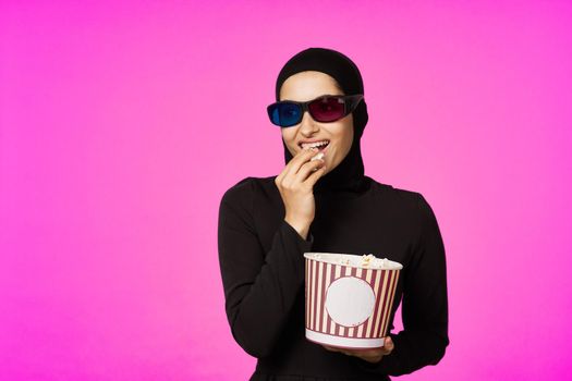 Muslim woman attractive look popcorn glasses movie watching studio lifestyle. High quality photo