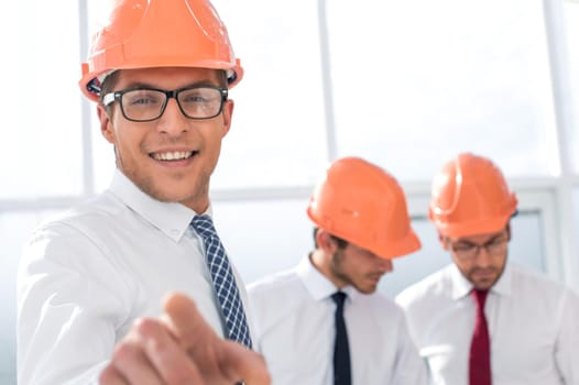 close up.smiling businessman architect showing at you.the concept of cooperation