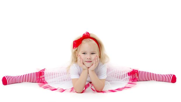 Little girl schoolgirl, performs gymnastic twine in the studio on a white background. Concept of fitness and sport and healthy lifestyle.