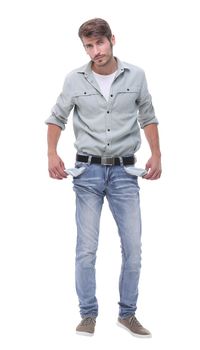 in full growth.young man showing his empty pockets.isolated on white background