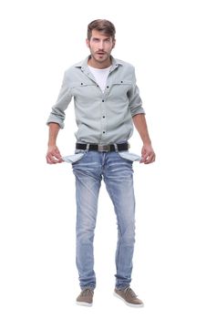 in full growth.young man showing his empty pockets.isolated on white background