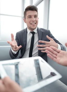 man having tablet in hands,having conference, conversation with her partners, one man on blurred background