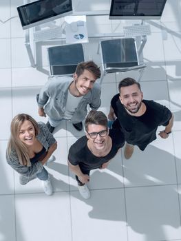 young businesspeople looking up with arms crossed at the waist