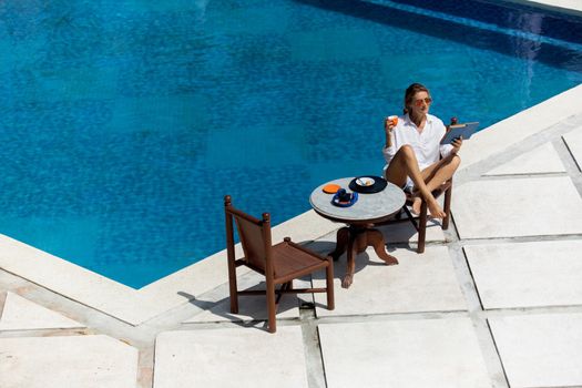 beautiful woman having breakfast near the pool. high quality photo