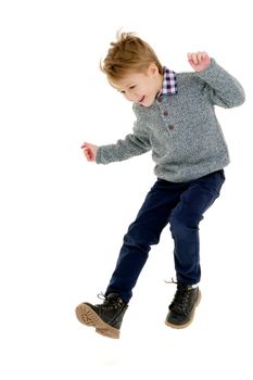 Little boy jumping fun in the studio on a white background. The concept of a happy childhood, sports and fitness. Isolated.