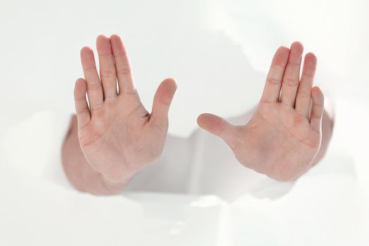 man breaking through a paper wall and showing a stop gesture.photo with copy space