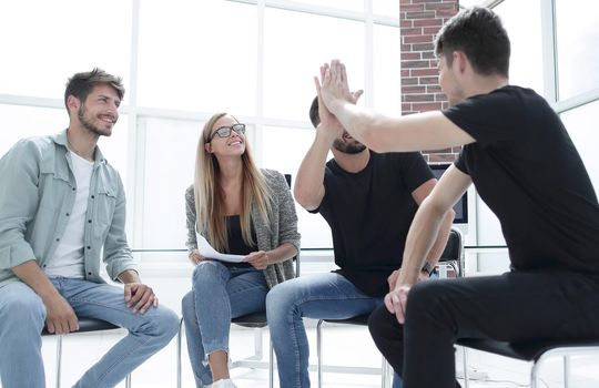 Businessman passing agreement to the business partner in conference room. Group of businessmen and businesswomen working together.