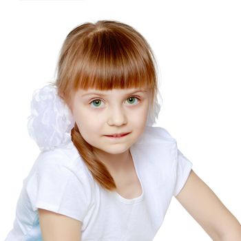 Funny little blonde girl with pigtails and white bows on her head in a white T-shirt and shorts.She hid behind the white banner ad and peeks out because of him.