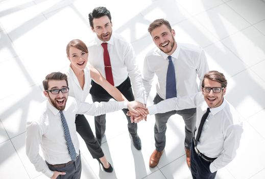 top view. young employees folding their hands together. photo with copy space