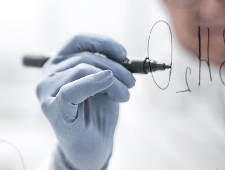 background image.scientist making notes on a transparent Board.close up