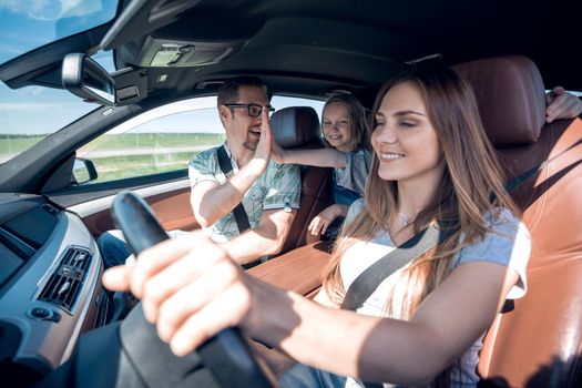 young mother with her family travels in a car .the concept of freedom and travel