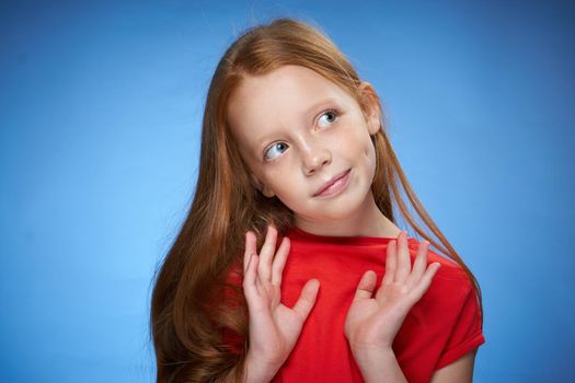 cheerful cute red-haired girl childhood blue background. High quality photo