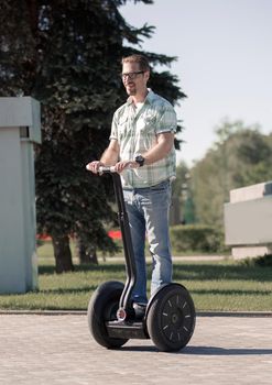 happy modern man riding a mini hoverboard in the Park. the concept of leisure