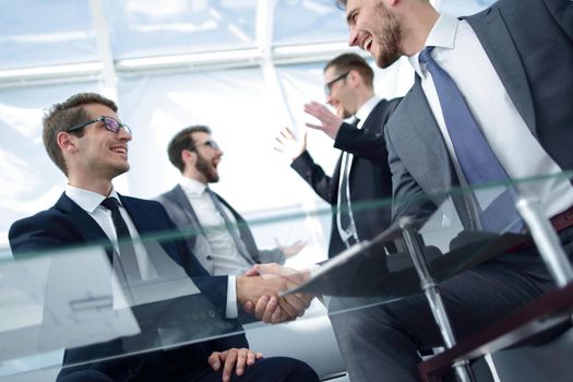 bottom view.businessmen shaking hands at the negotiating table .the concept of cooperation