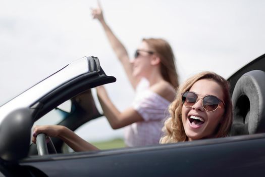 close up.two girlfriends traveling in a convertible car . fashionable lifestyle