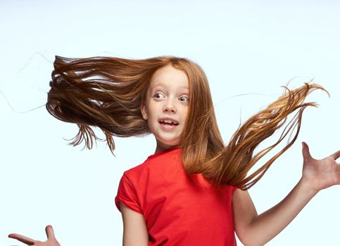 girl with red hair posing red t-shirt childhood. High quality photo