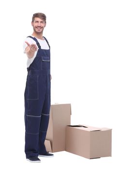 in full growth. man courier standing near cardboard boxes.isolated on white background