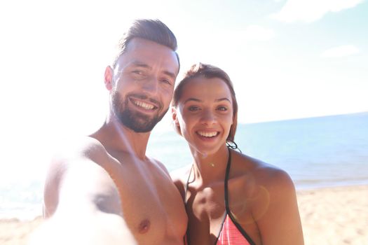 Romantic couple taking selfie on the beach.