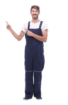 in full growth. smiling man in blue work suit pointing to copy space. isolated on white background