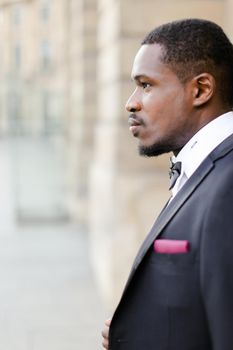 Portrait of afro american happy man wearing suit and standing outside. Concept of black businessman.