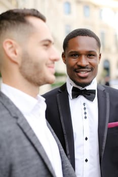 Focus on afro american man standing near caucasian boy wearing suit. Concept of businessman and business.