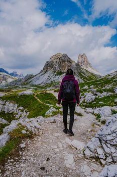 Tre Cime di Lavaredo peaks or Drei Zinnen at sunset, Dobbiaco Toblach, Trentino -Alto Adige or South Tyrol, Italy. Europe Alps. Asian woman hiking in the mountains