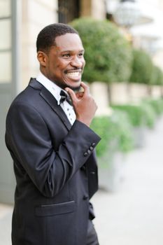 Afro american happy good looking male person wearing suit and smiling. Concept of black businessman.