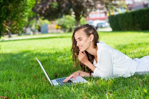 young attractive woman in the park with a laptop.