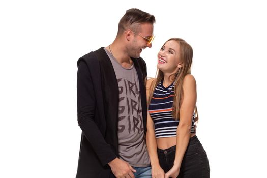 Happy young lovely couple standing together and laughing. Studio shot over white background. Friendship, love and relationships concept