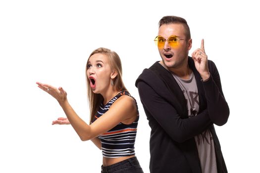 Couple watching look at something and have different emotions concept. Studio shot on white background. Copy space