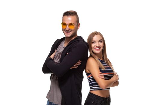 Studio shot of beautiful young couple standing back to back and looking at the camera on white background