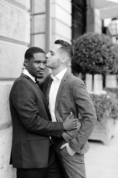 Black and white photo afro american gay hugging european man outdoors. Concept of lgbt and same sex couple.