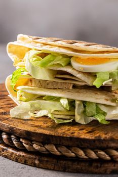 Healthy homemade tortilla wrap with freshly made green Caesar salad. Concept of social media trendy food.