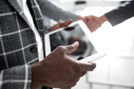 close up.businessman with digital tablet standing in office.people and technology