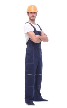 in full growth. confident man wearing overalls and a crash helmet. isolated on white background