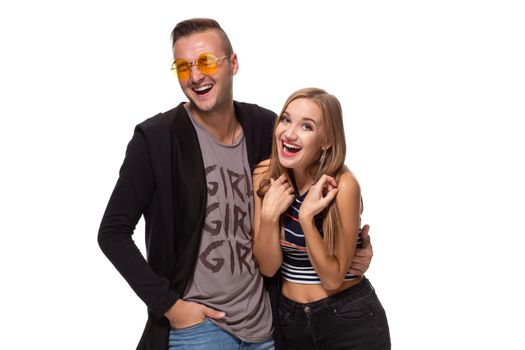 Happy young lovely couple standing together and laughing. Studio shot over white background. Friendship, love and relationships concept