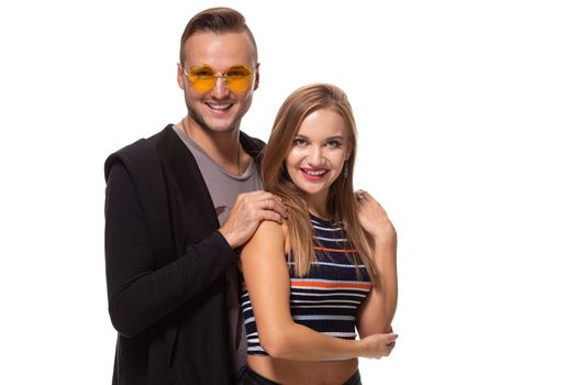 Happy young lovely couple standing together and laughing. Studio shot over white background. Friendship, love and relationships concept