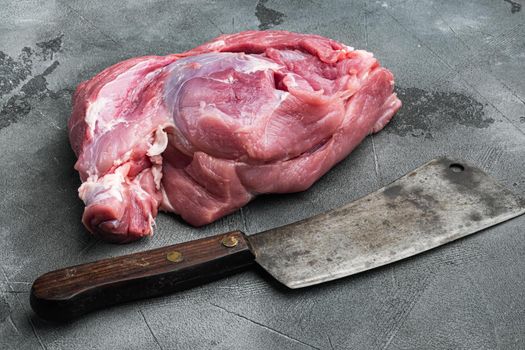 Raw meat, piece of pork set , with old butcher cleaver knife, on gray stone table background