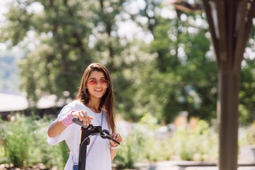 Young beautiful woman and an electric scooter, modern girl, new generation, electric transport, ecological transport