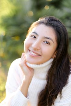 Portrait of chinese smiling woman sitting outdoors. Concept of asian female person and beauty.