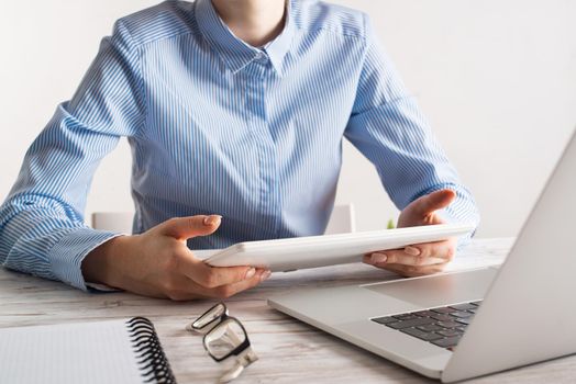 Business lady sitting at desk with tablet computer. Corporate office workplace with laptop. Mobile smart device in business processes. Business occupation concept with business woman at wooden desk.