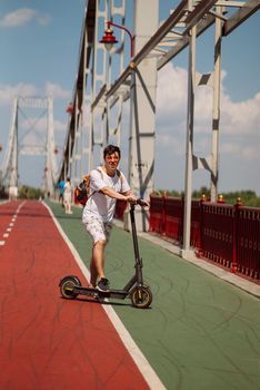 Guy in casual clothes rented an e-scooter.